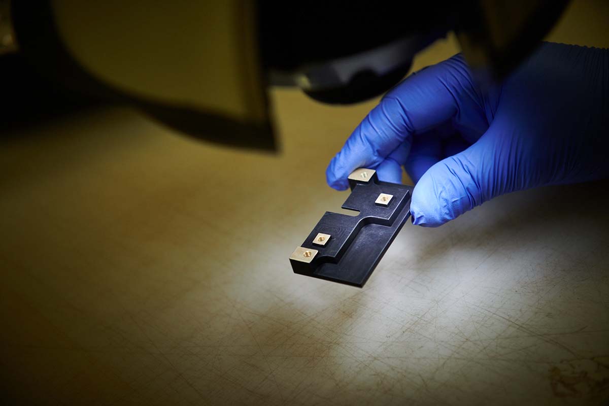 A metal part being closely examined