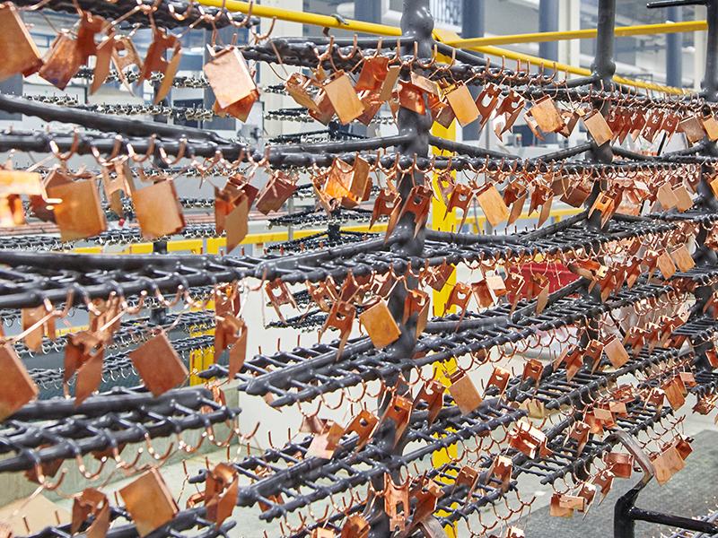 Copper metal pieces hanging on a rack
