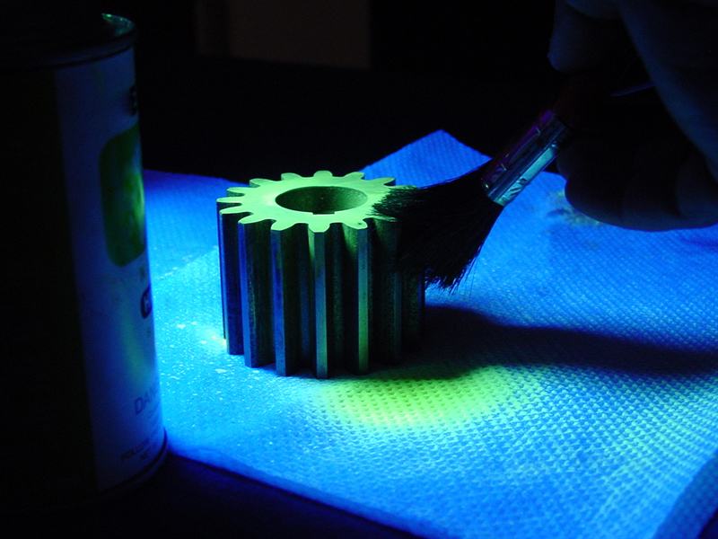 Metal gear being brushed with a treatment