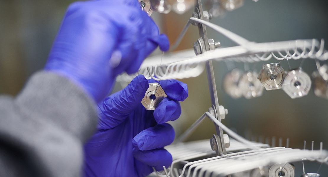 Small metal pieces being hung on a rack